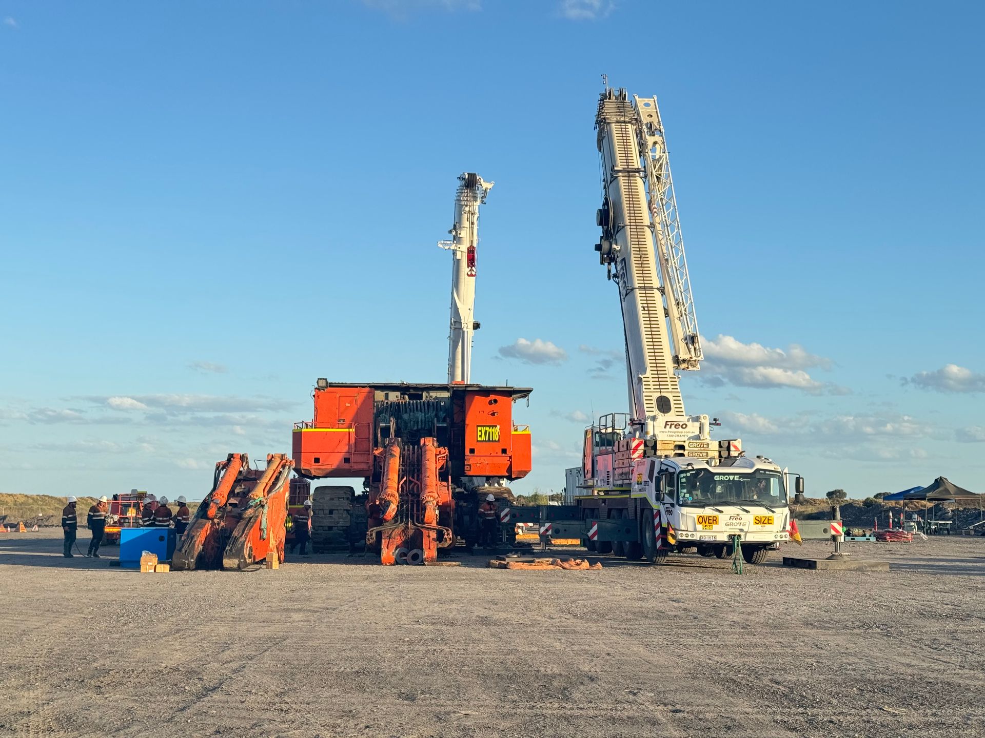 Orange and white construction machinery at a work site under a clear blue sky — Resurge Diesel & Fabrication Pty Ltd In Balnagowan, QLD