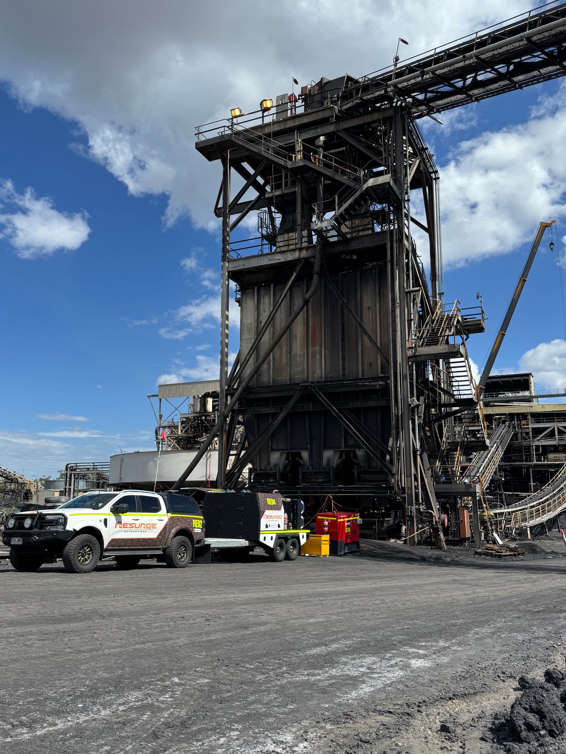 Charred industrial structure with firefighting vehicles and equipment under a blue sky — Resurge Diesel & Fabrication Pty Ltd In Balnagowan, QLD