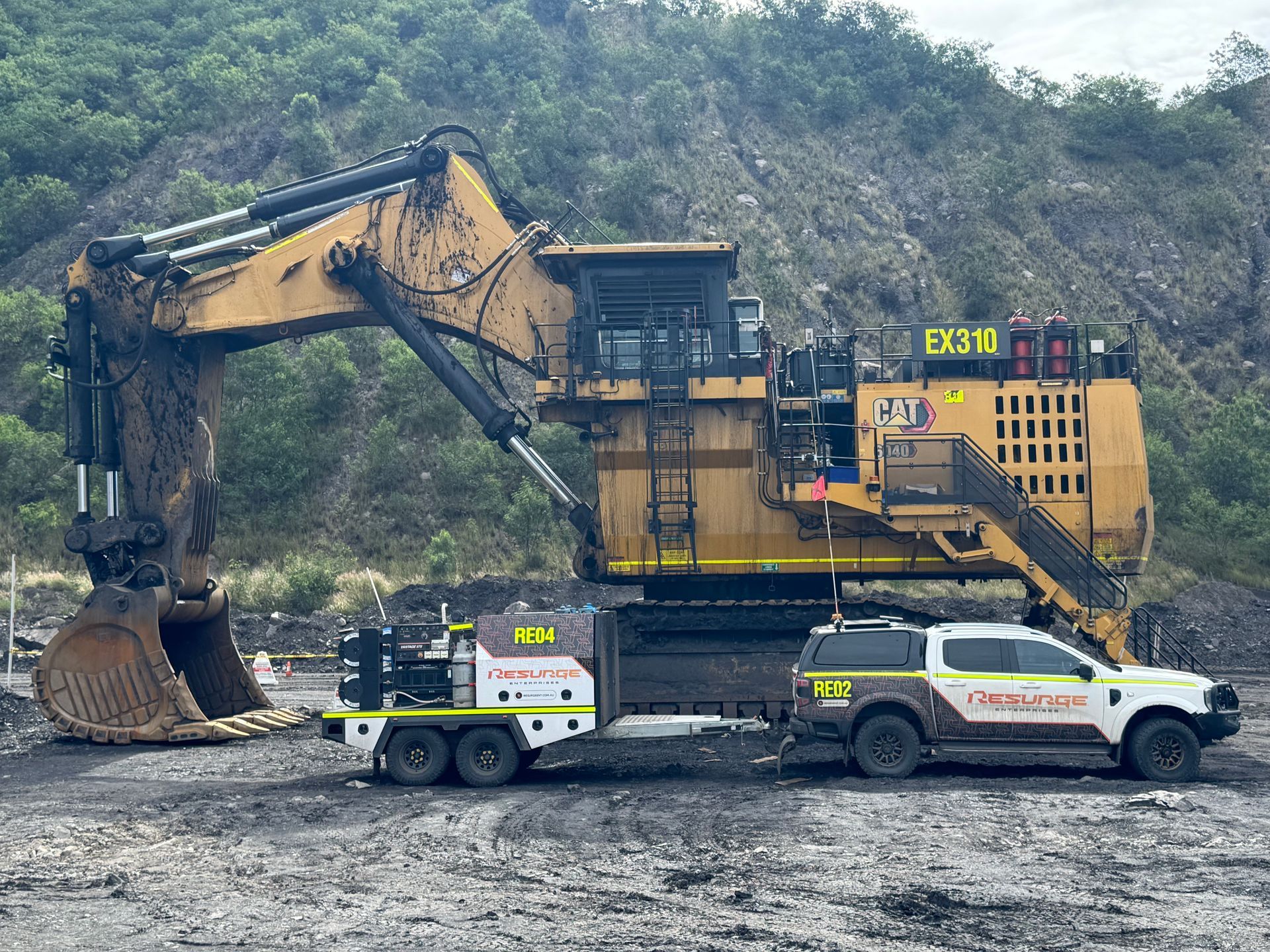 Yellow Backhoe Loader On A Construction Site, With Front Bucket Holding Dirt Under A Cloudy Sky — Resurge Diesel & Fabrication Pty Ltd In Balnagowan, QLD