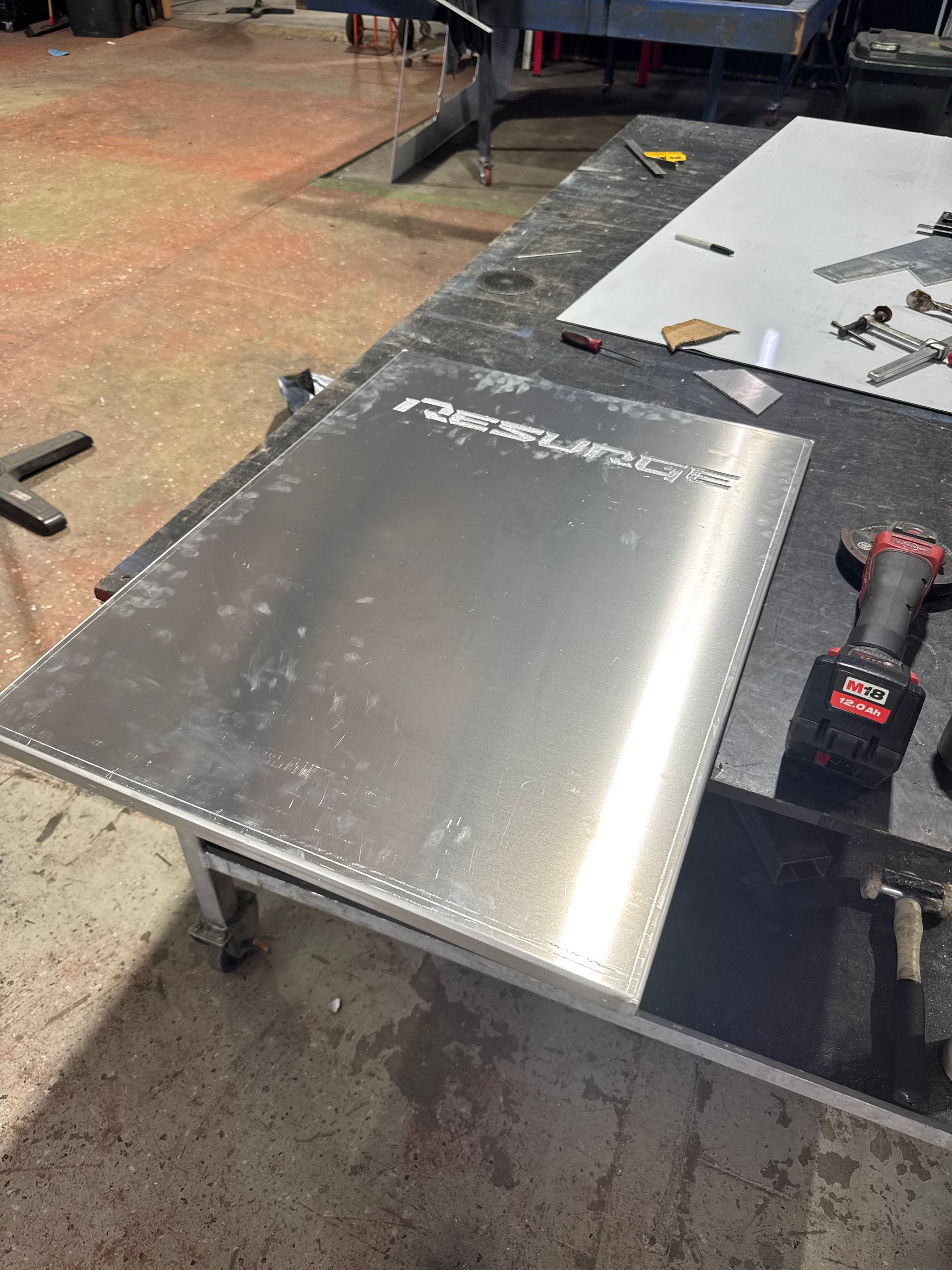 Silver laptop on a workbench beside a drill in a workshop — Resurge Diesel & Fabrication Pty Ltd In Balnagowan, QLD