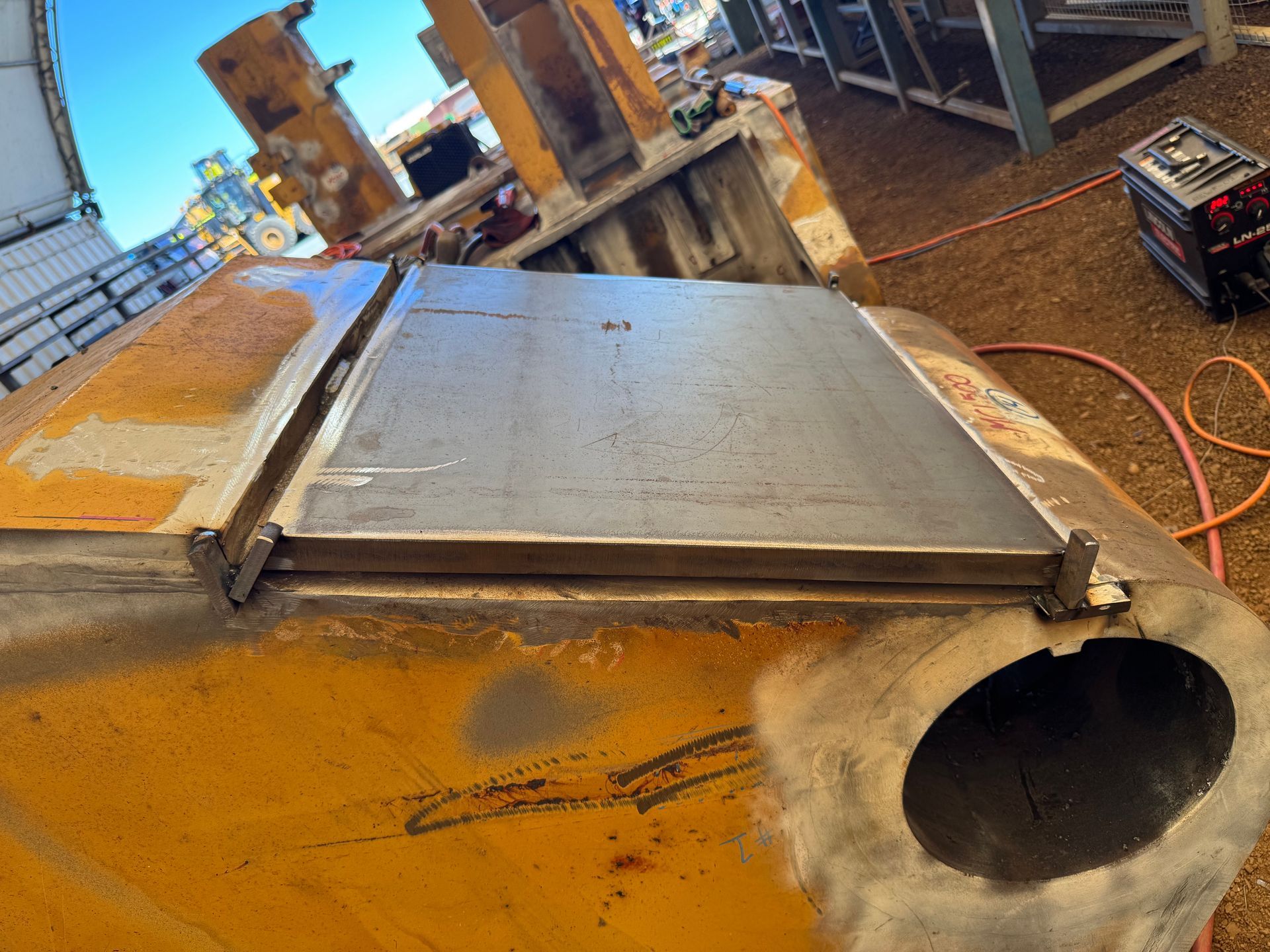 Yellow industrial machinery with a metal top plate and large round opening in a workshop setting — Resurge Diesel & Fabrication Pty Ltd In Balnagowan, QLD