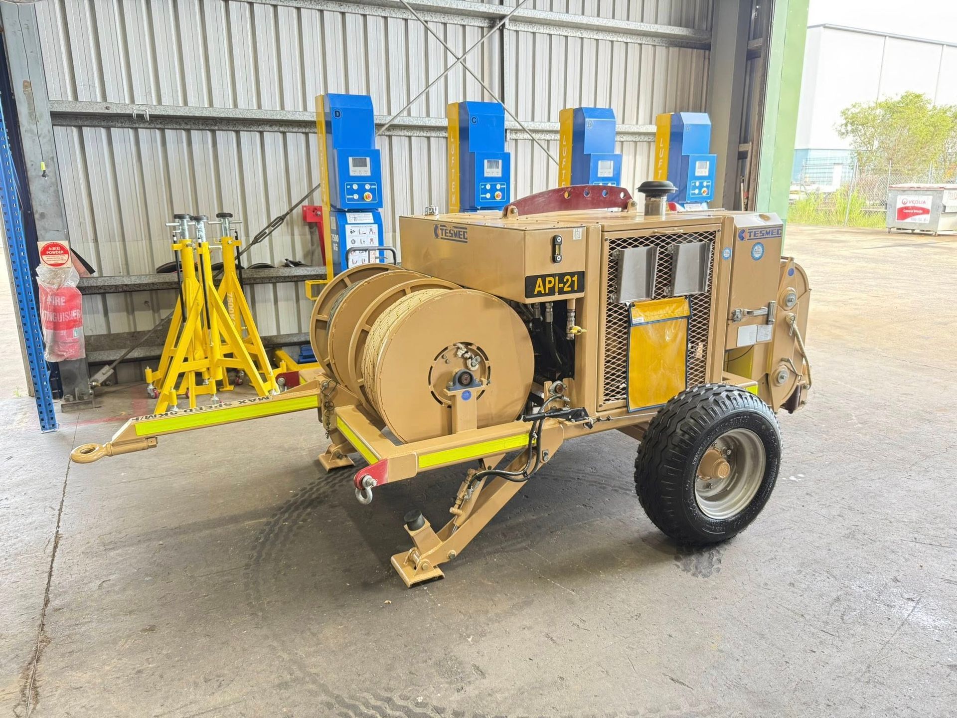 Yellow industrial machine on a trailer inside a warehouse, with blue equipment stands in the background — Resurge Diesel & Fabrication Pty Ltd In Balnagowan, QLD