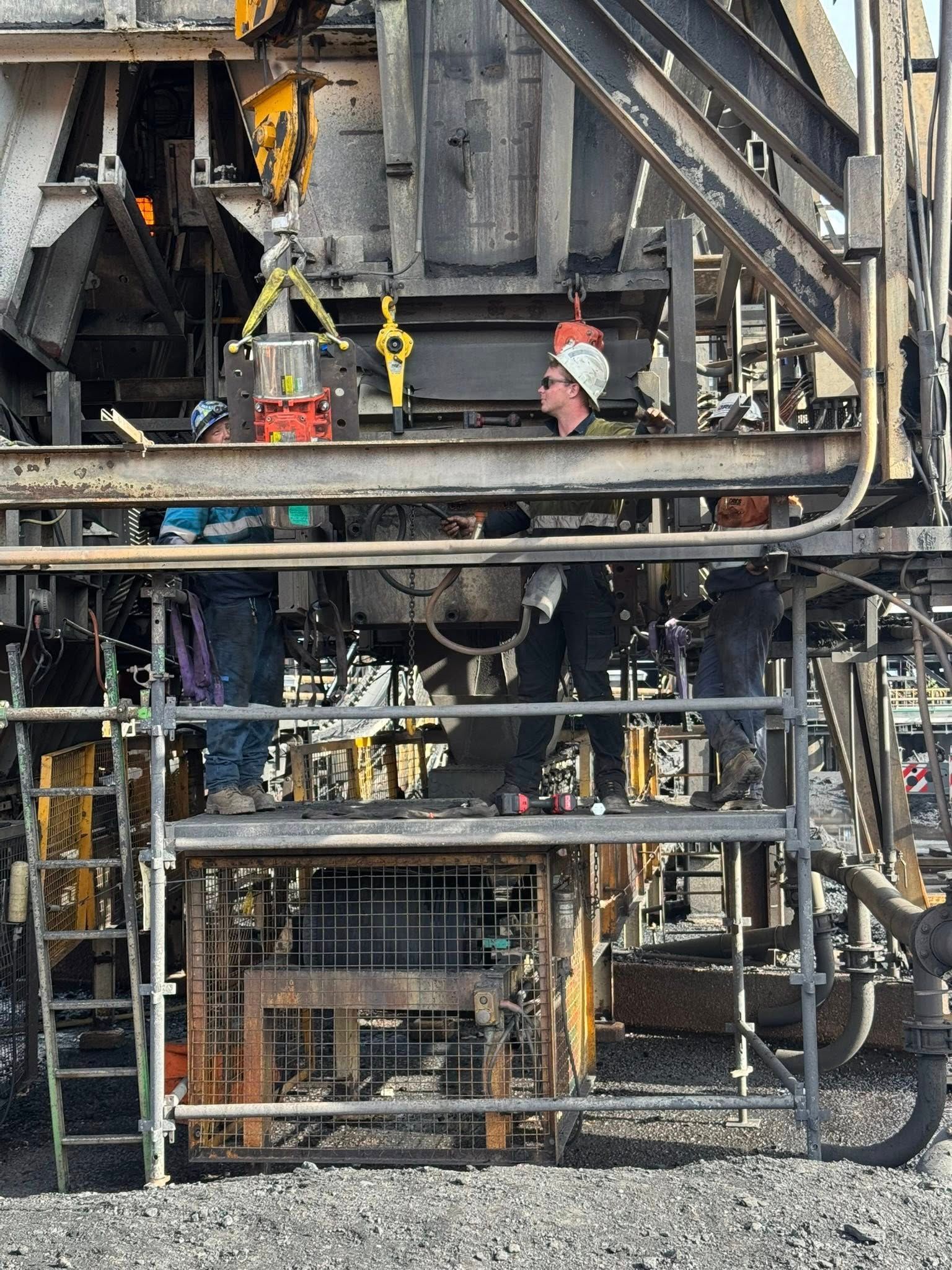 Workers in hard hats on a metal platform inside an industrial construction site — Resurge Diesel & Fabrication Pty Ltd In Balnagowan, QLD
