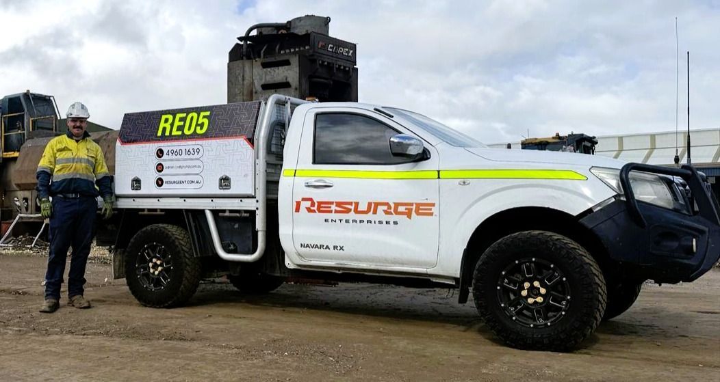 White rescue truck with RE05 marking and a person in safety gear standing beside it on a muddy roadside — Resurge Diesel & Fabrication Pty Ltd In Balnagowan, QLD