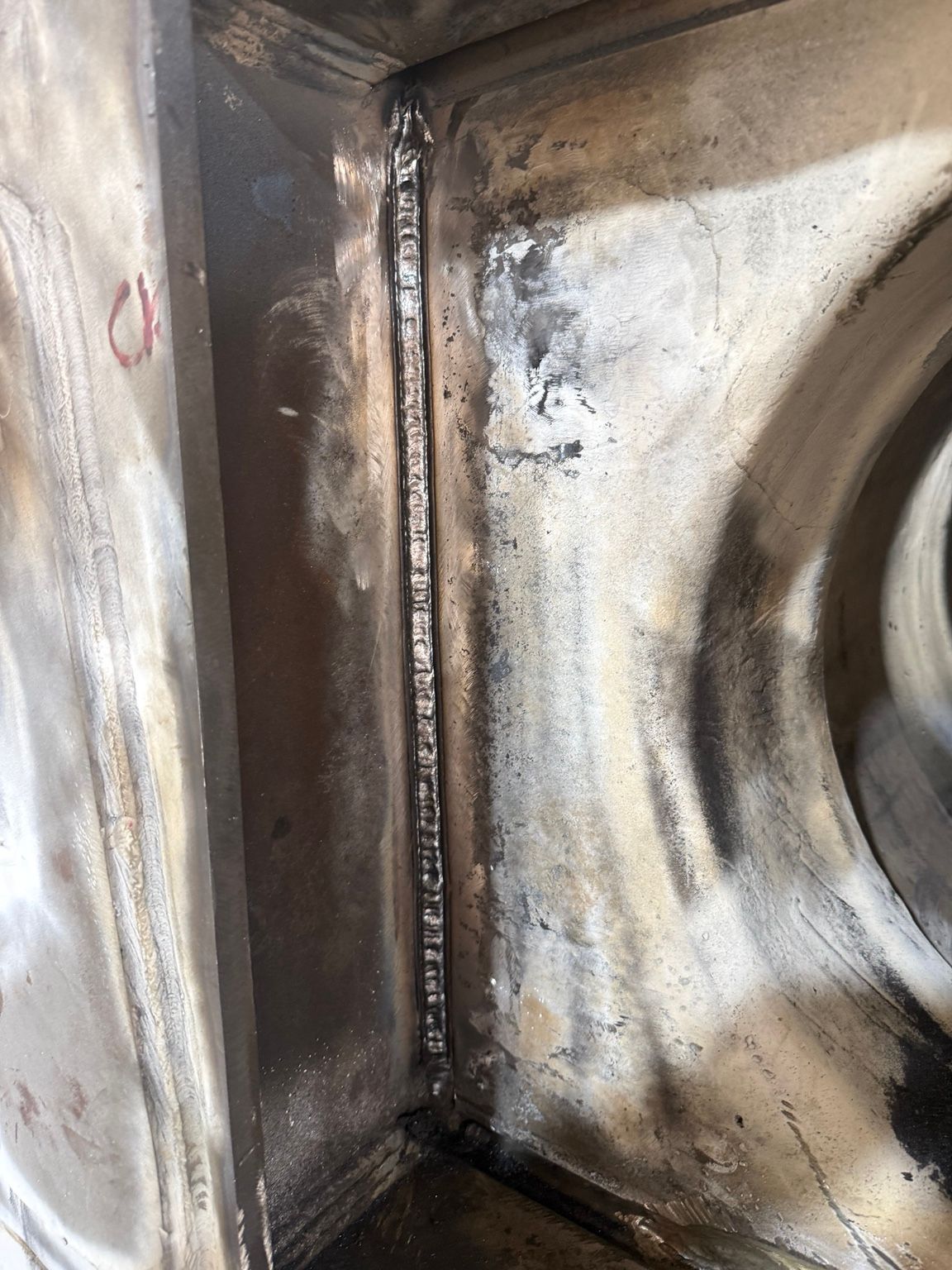 Close-up of a dirty metal corner with welded seams and dark stains — Resurge Diesel & Fabrication Pty Ltd In Balnagowan, QLD