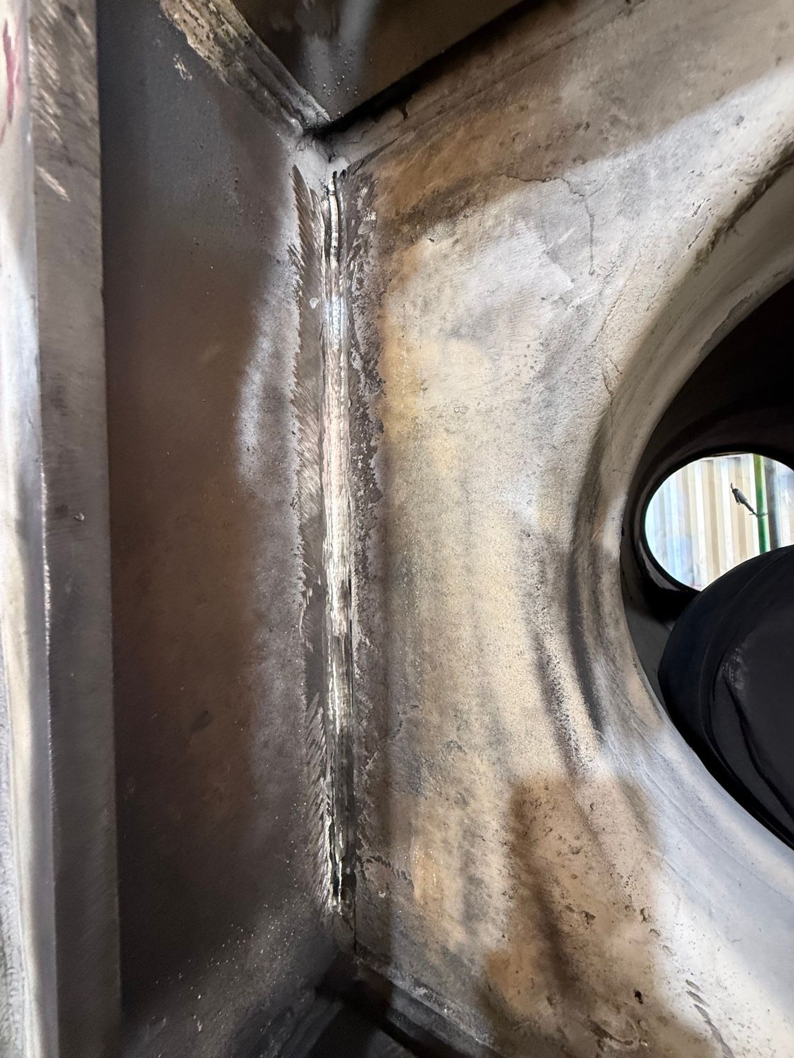 Close-up of a metal surface with weld seams and a circular opening on the right — Resurge Diesel & Fabrication Pty Ltd In Balnagowan, QLD