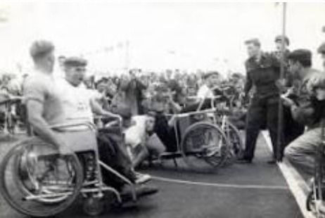 A black and white photo of a group of people in wheelchairs at the Paralympics.