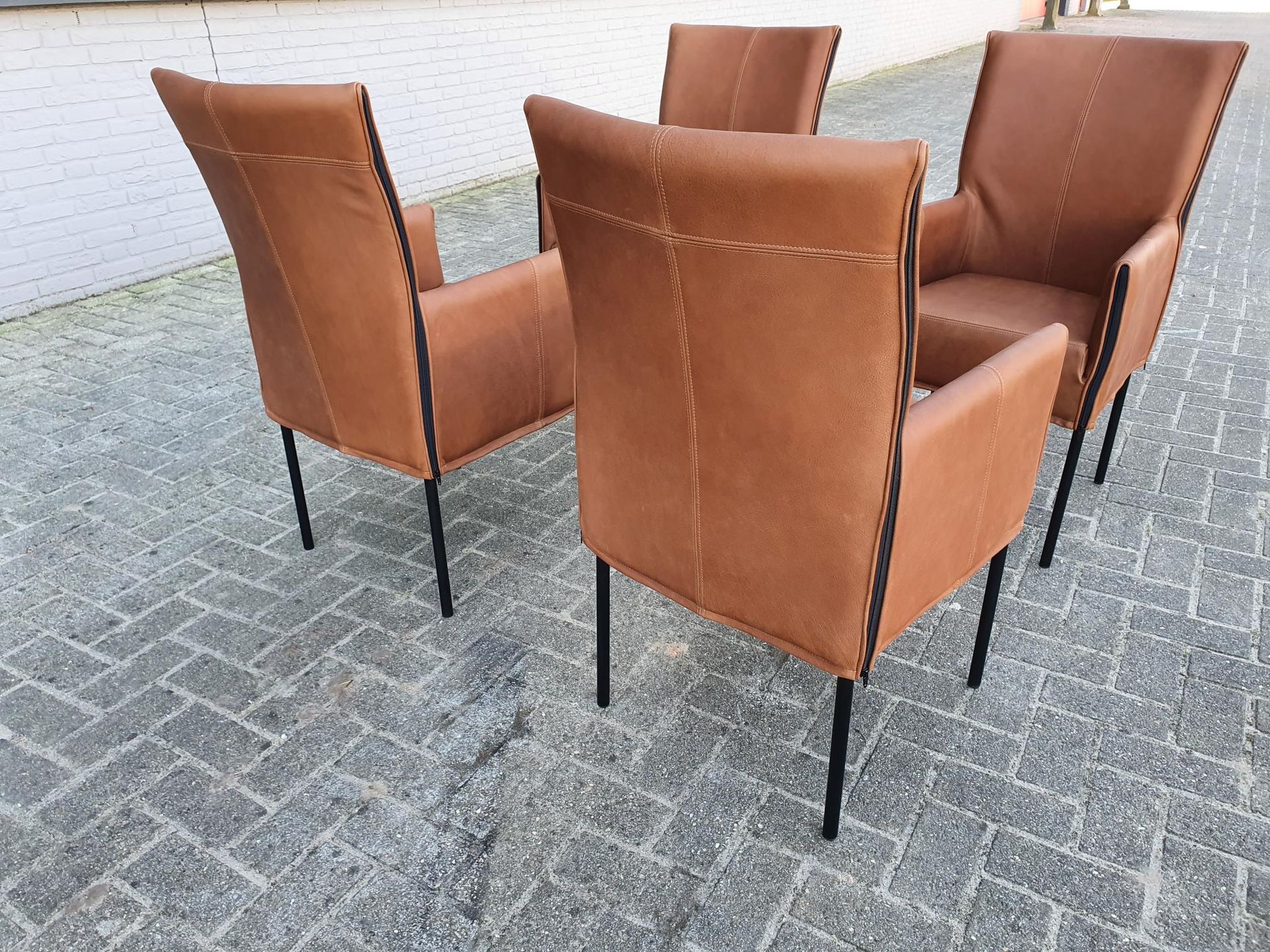 Vier lichtbruine cognac leren Eetkamerstoelen met zwarte metalen poten