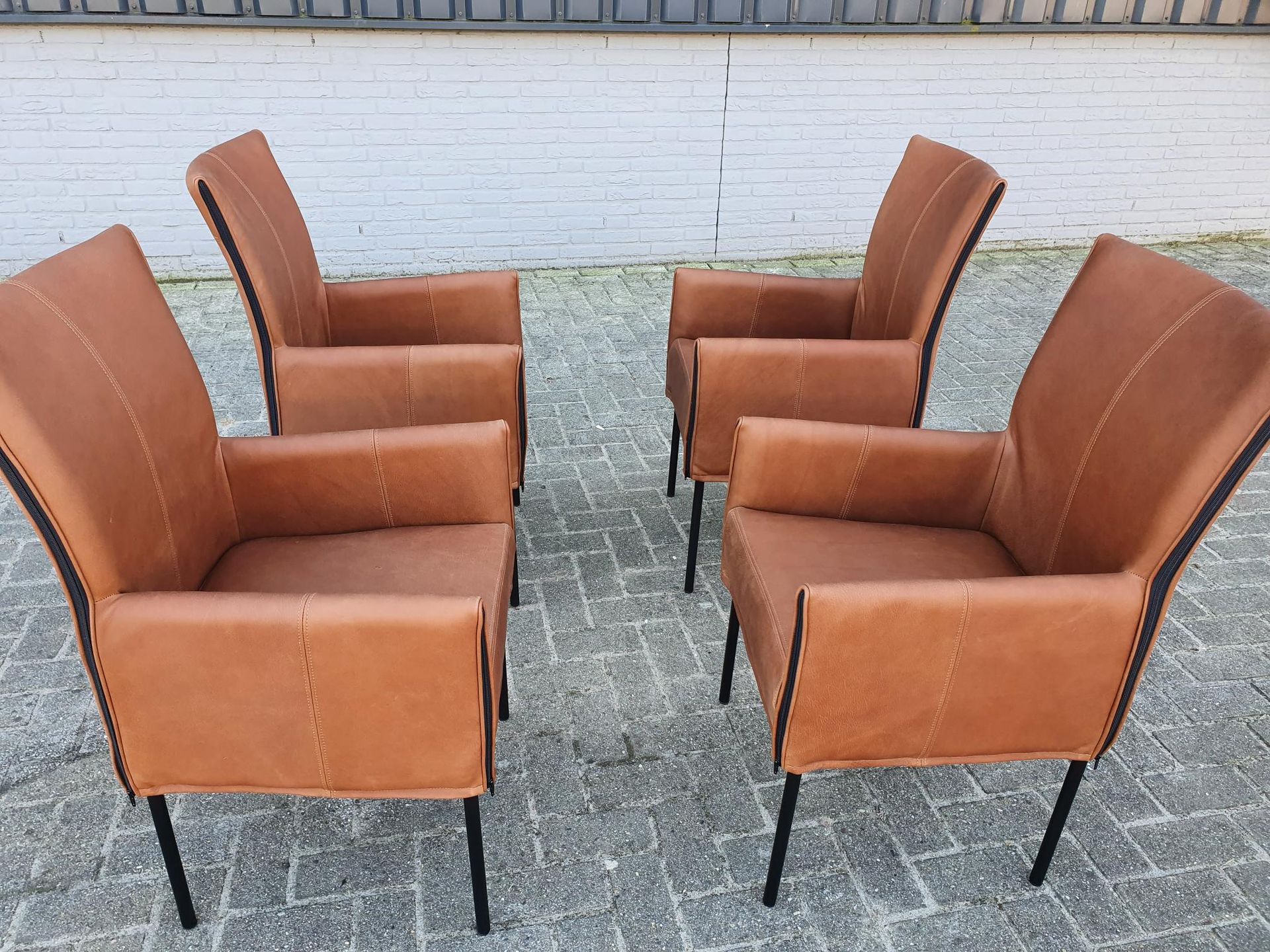 Vier lichtbruine cognac leren Eetkamerstoelen met zwarte metalen poten