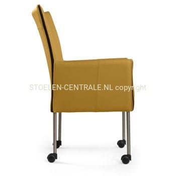Een moderne, mosterdgele eetkamerstoel met hoge rugleuning, dunne metalen poten en zwarte wieltjes.