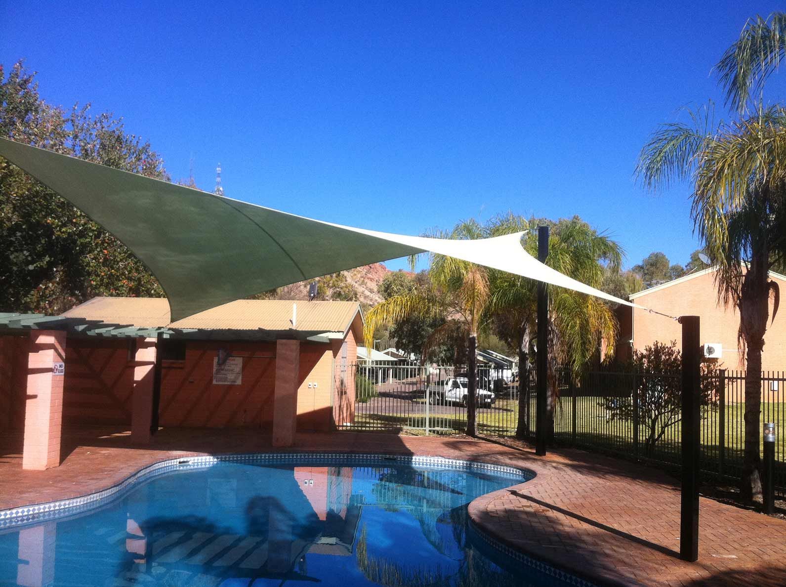 A Shade Sail Over a Blue Swimming Pool — Shadetech in Alice in Ciccone, NT