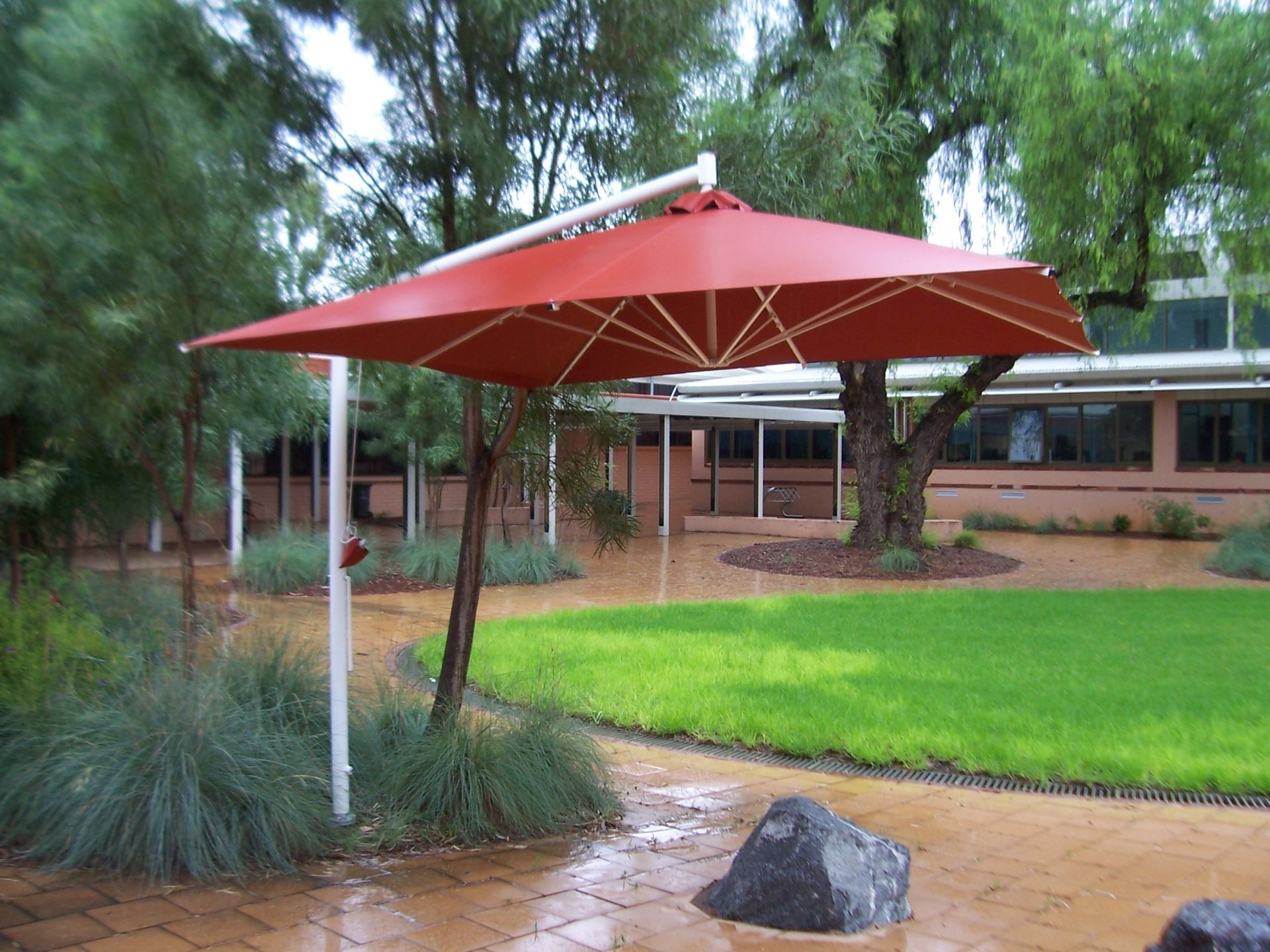 A Red Umbrella Over A Swimming Pool — Shadetech in Alice in Ciccone, NT