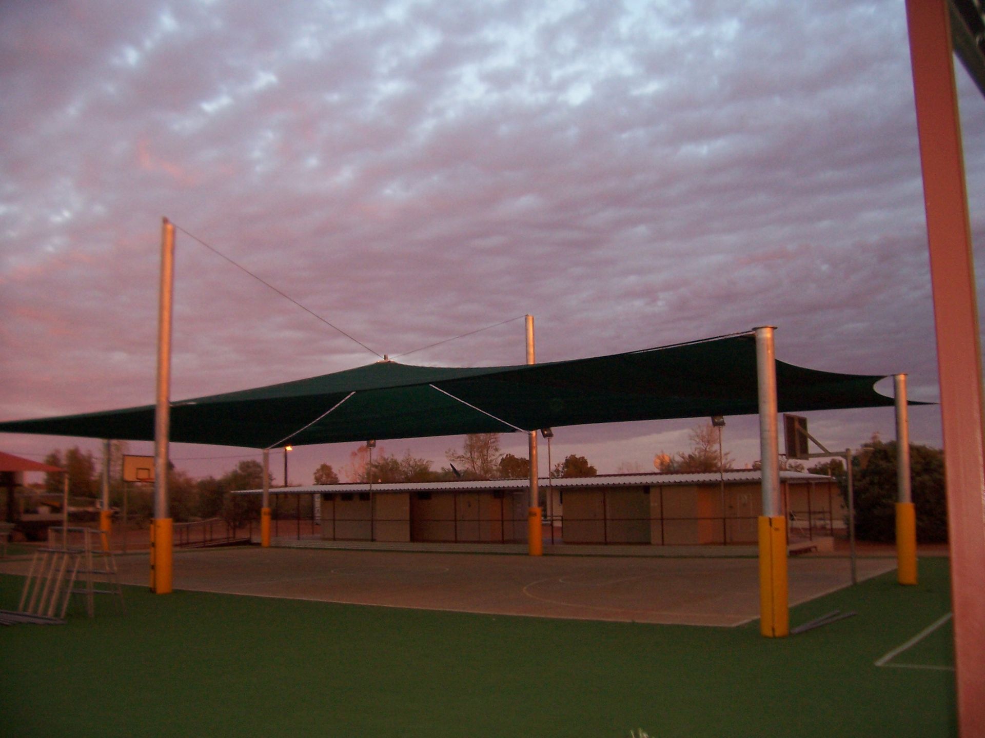 A Large Green Shade Sail Is Covering A Basketball Court  — Shadetech in Alice in Ciccone, NT