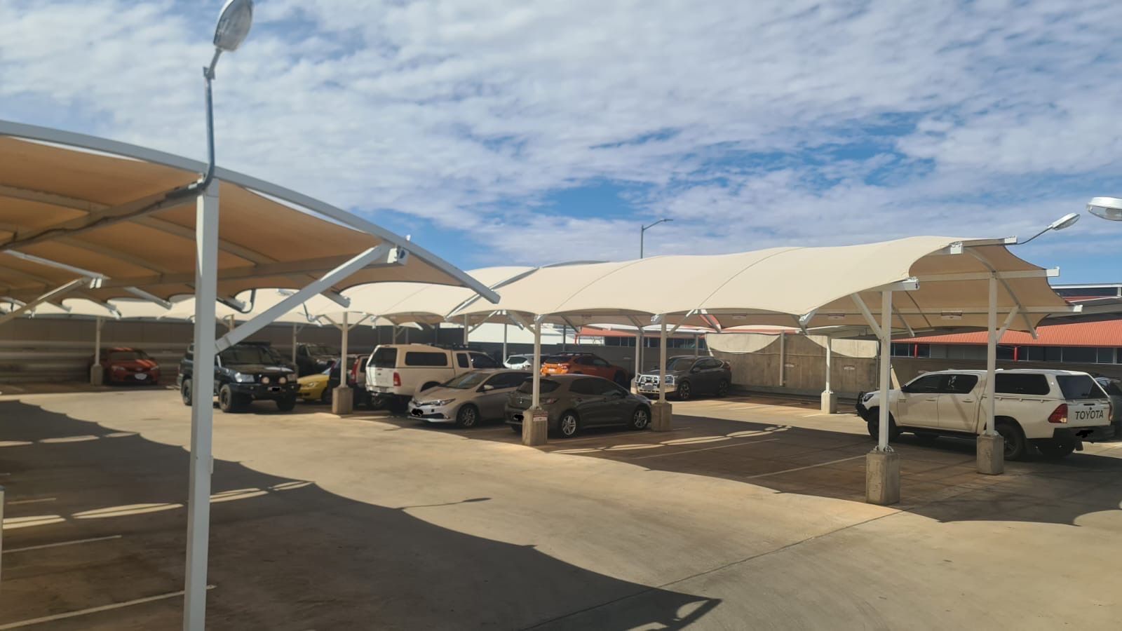 A Carpark With Cars Parked Under Shade Sails — Shadetech in Alice in Ciccone, NT
