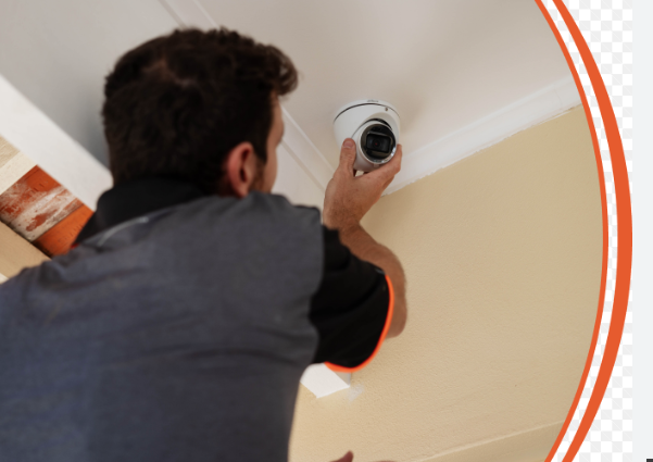 a man is installing a CCTV camera.