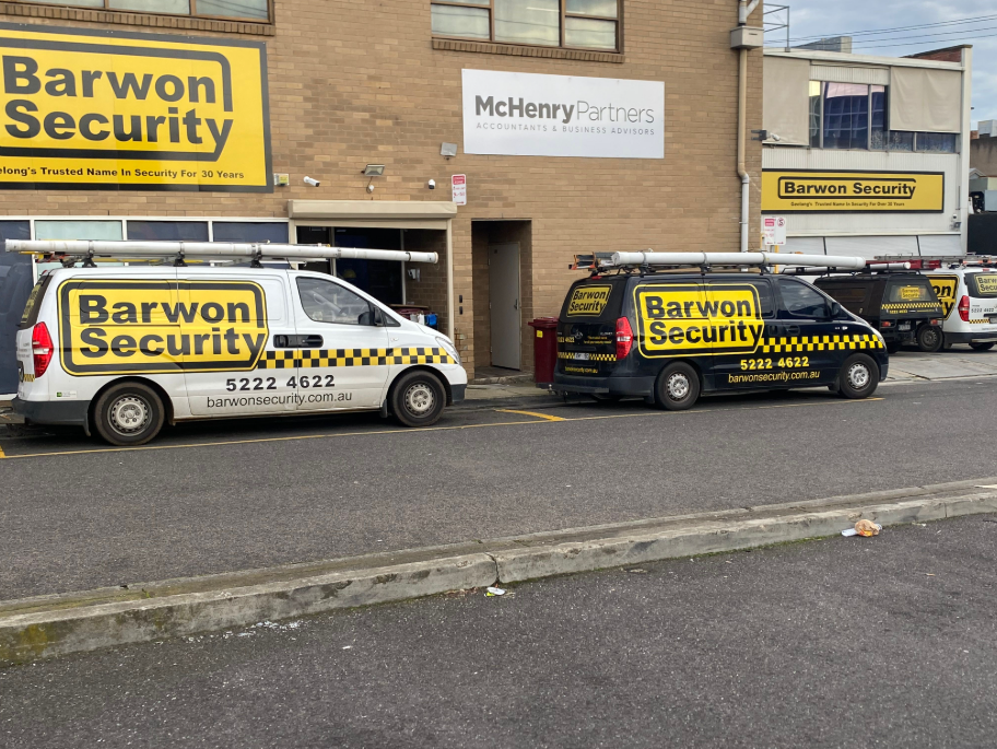 Barwon Security vans parked in front of a building with Barwon Security signage.