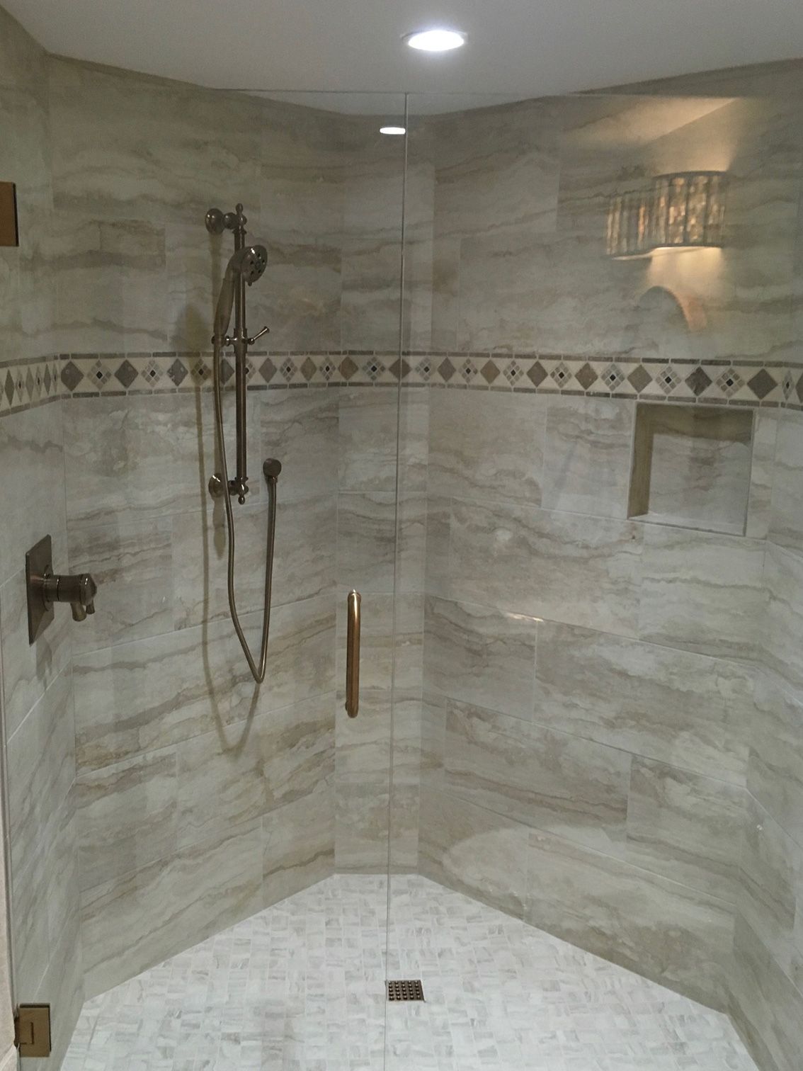 A shower with a glass door and a shower head