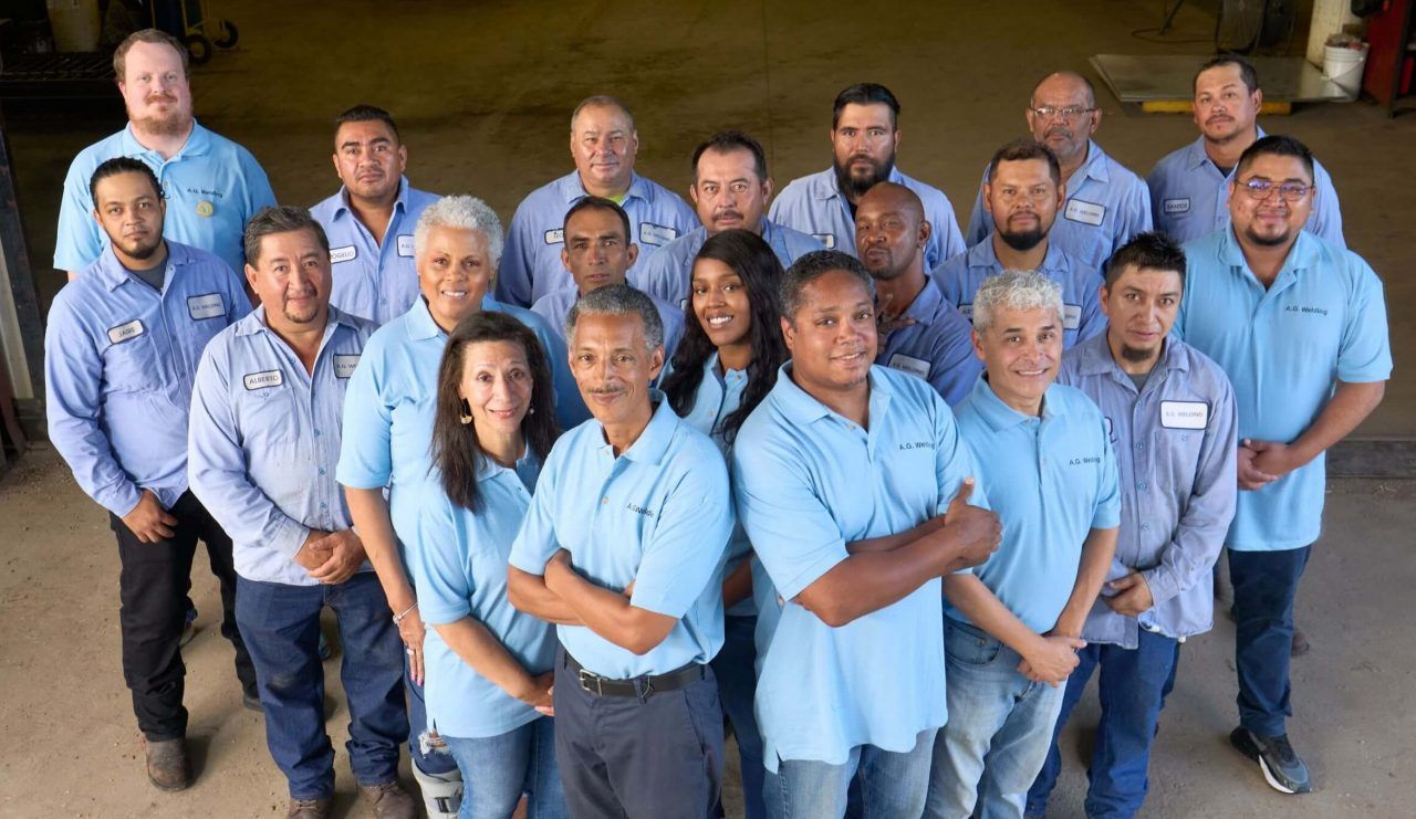 A group of people in blue shirts are posing for a picture.