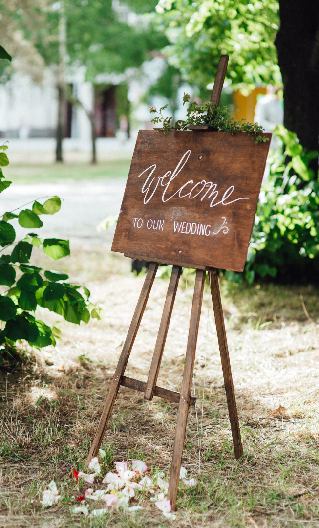 A wooden easel with a welcome sign on it.