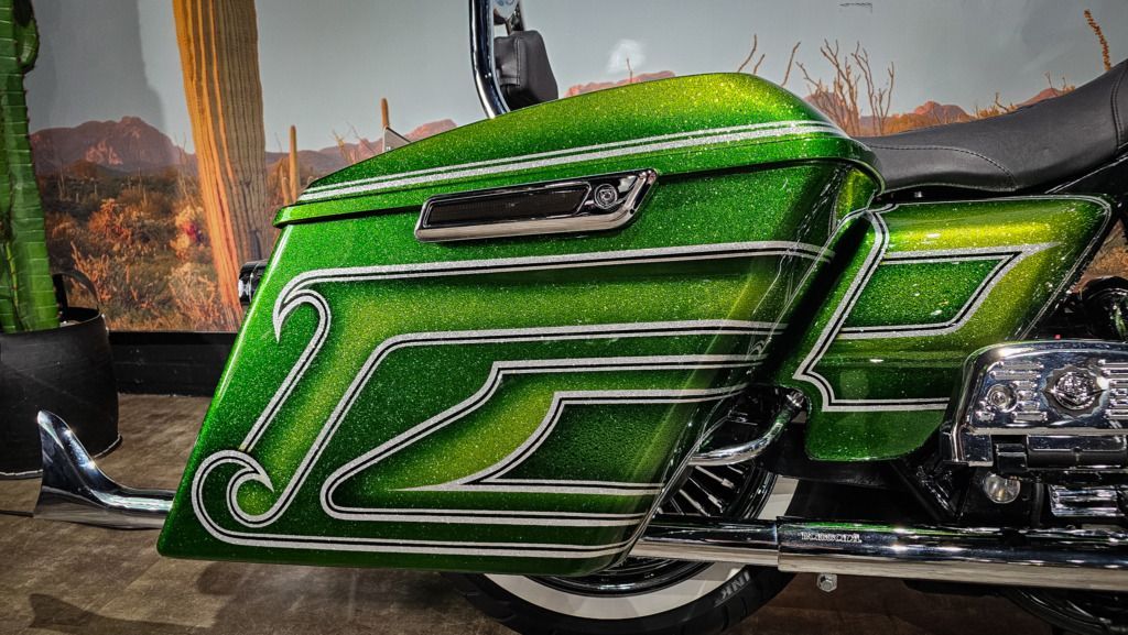 Een groene harley davidson-motorfiets staat geparkeerd in een garage.