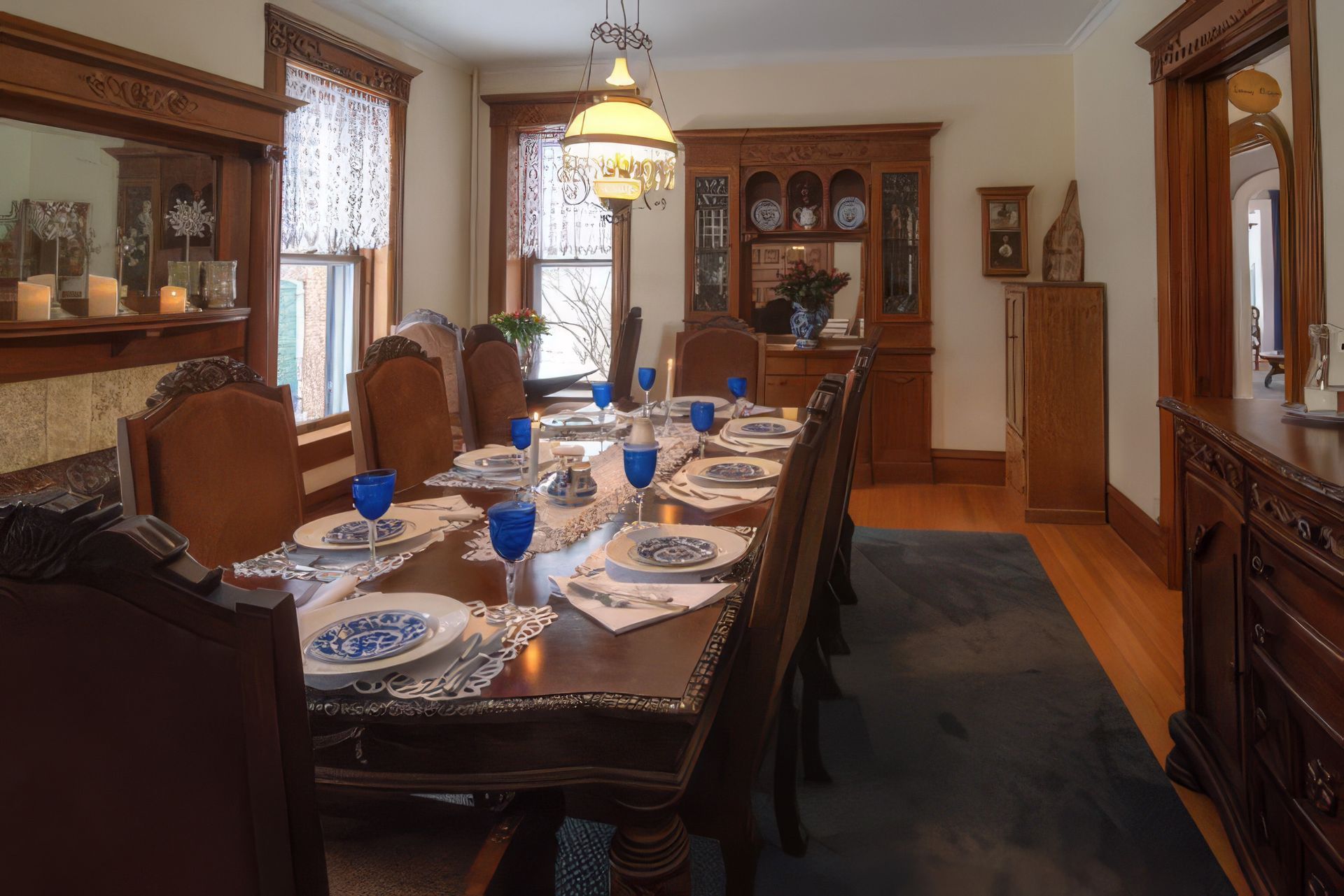 Elegant dining room with a long set table, wooden chairs, cabinets, and large windows