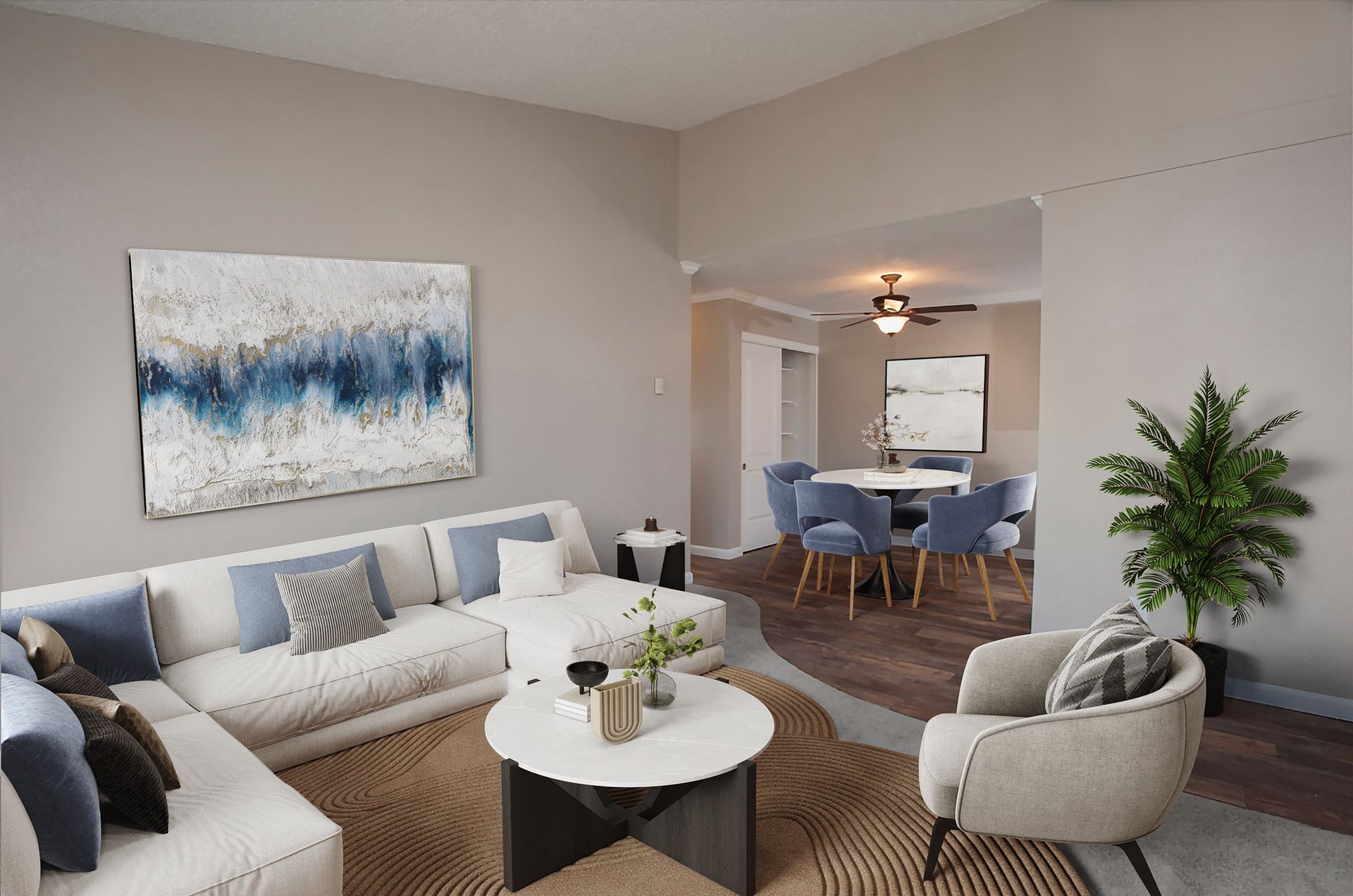 Open-concept living room and dining area in a modern apartment with neutral tones and blue accents at Ridgecrest Apartment Homes.