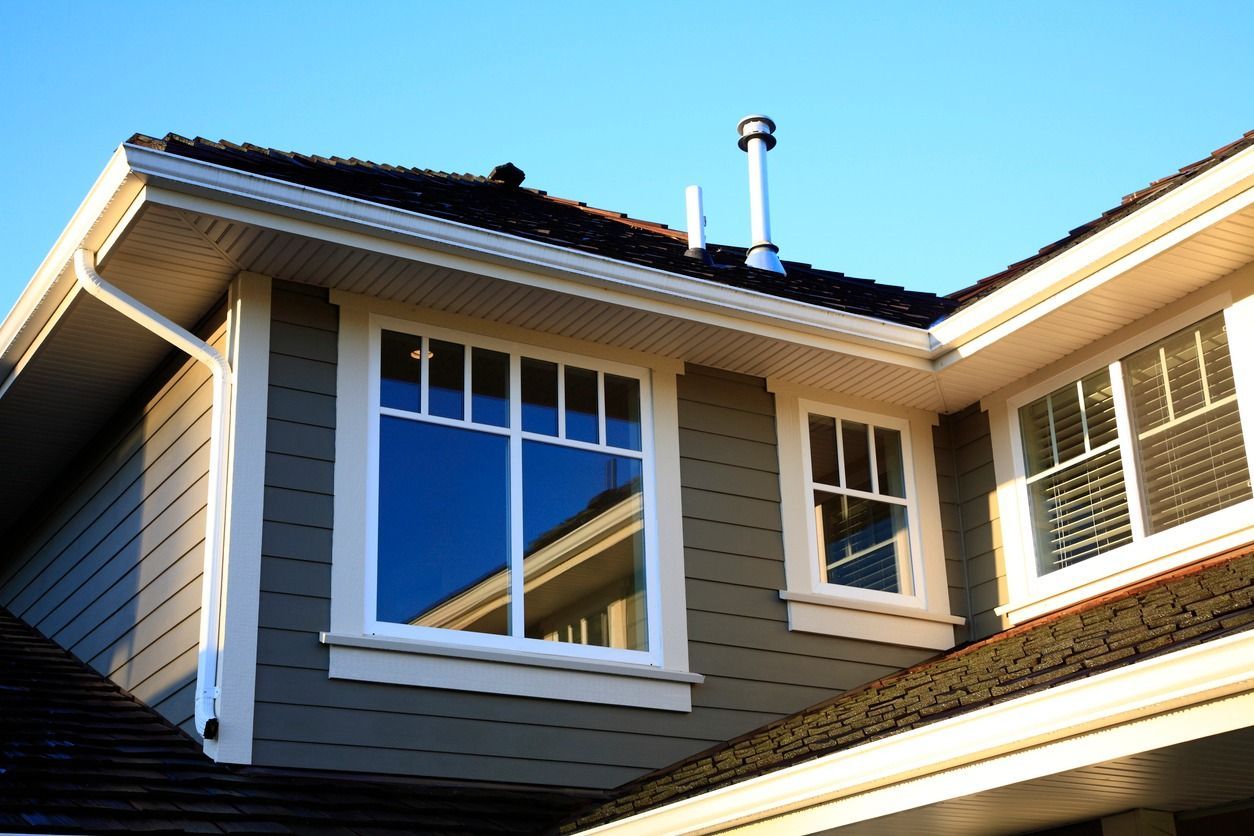 A house with a lot of windows and a chimney on the roof