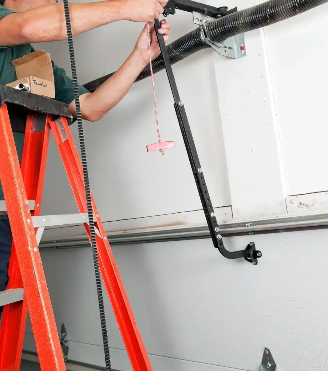 Man on ladder installing garage door arm.