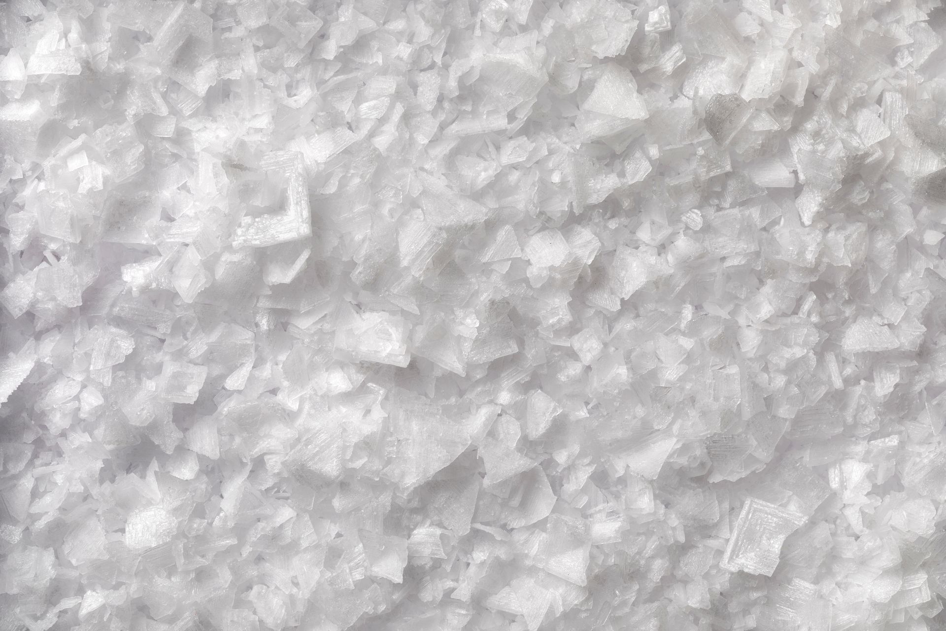 Close-up of white crystalline granules, like salt or sugar, filling the frame