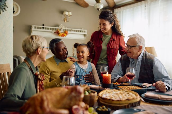 A family is sitting at a table for a thanksgiving dinner.