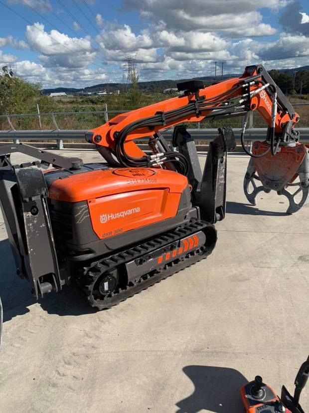 A Robotic Excavator Is Parked On The Side Of The Road — Newcastle Cut & Drill In Boolaroo, NSW
