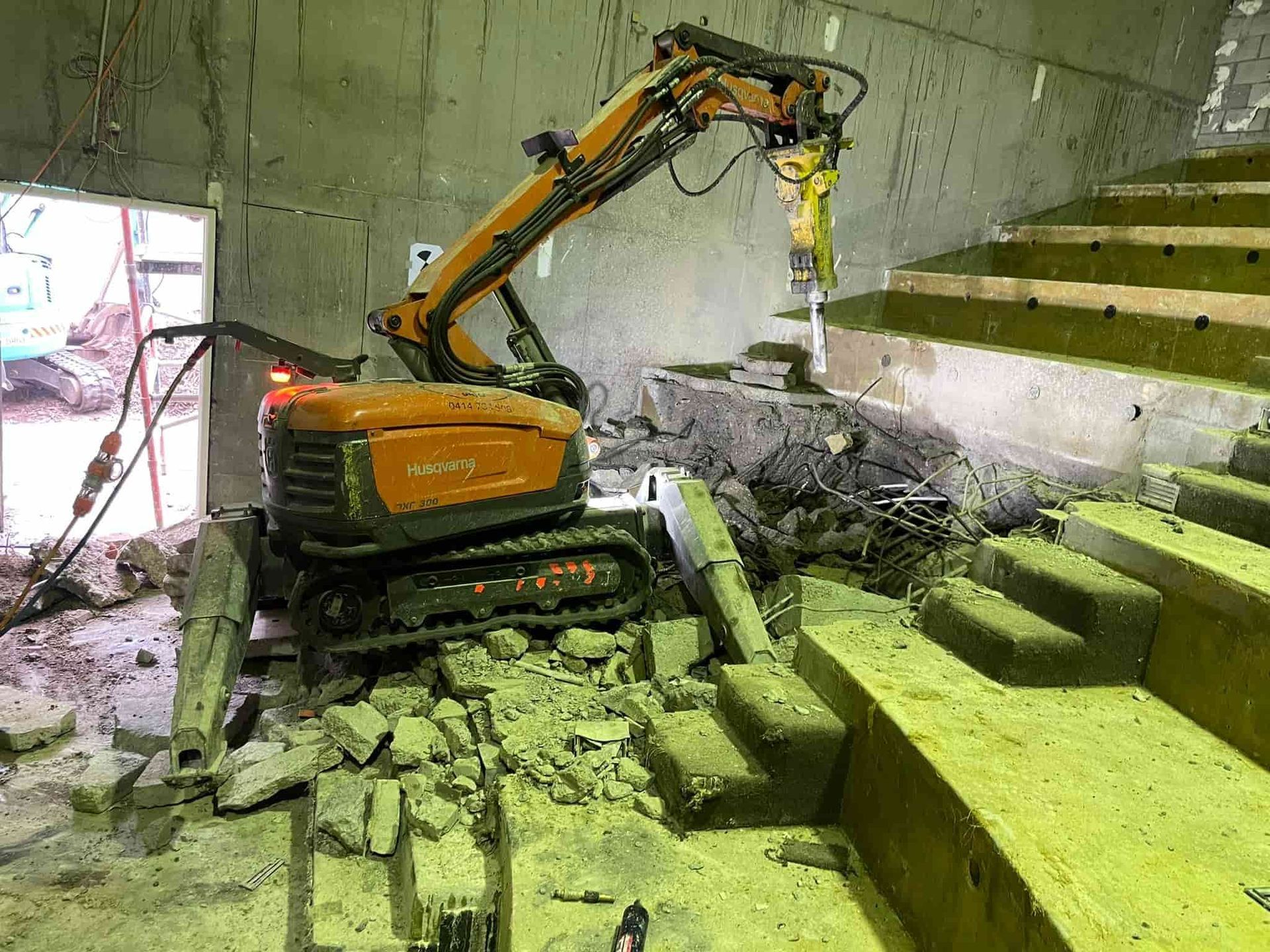 A robot is breaking concrete in a building next to stairs — Newcastle Cut & Drill In Boolaroo, NSW