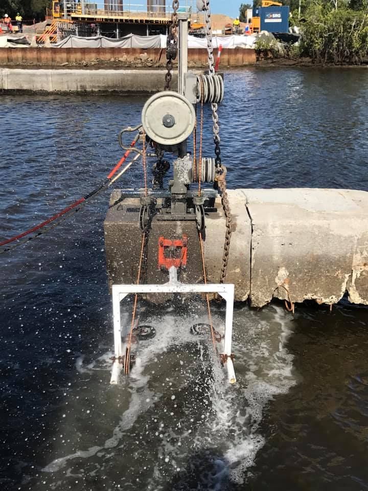 A machine is cutting a concrete pipe in the water — Newcastle Cut & Drill In Boolaroo, NSW