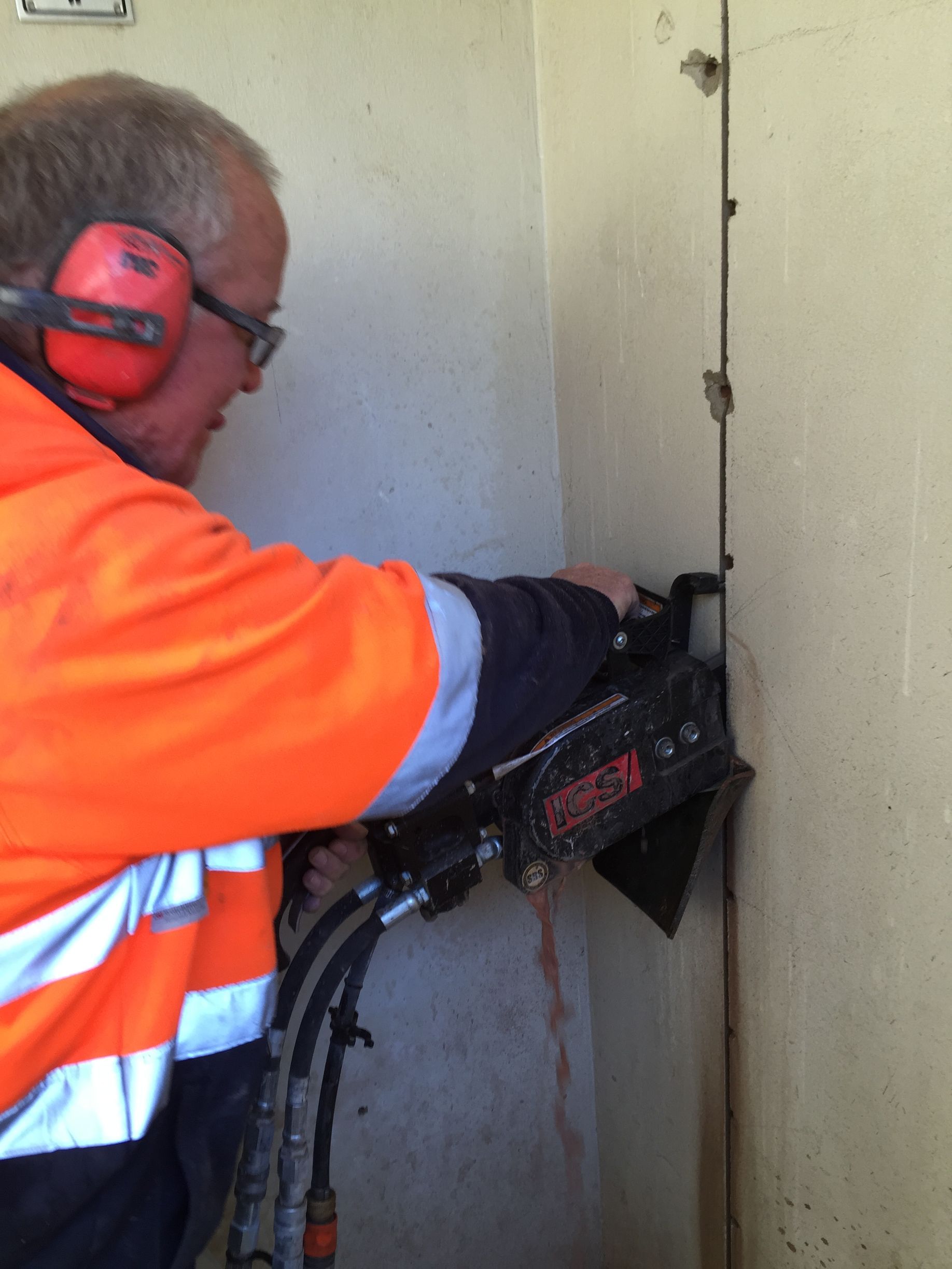 A man chain sawing into side of a building— Newcastle Cut & Drill In Boolaroo, NSW