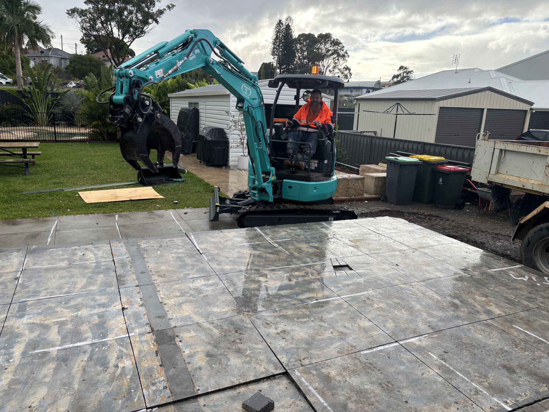 A man operating an excavator on a concrete slab — Newcastle Cut & Drill In Boolaroo, NSW