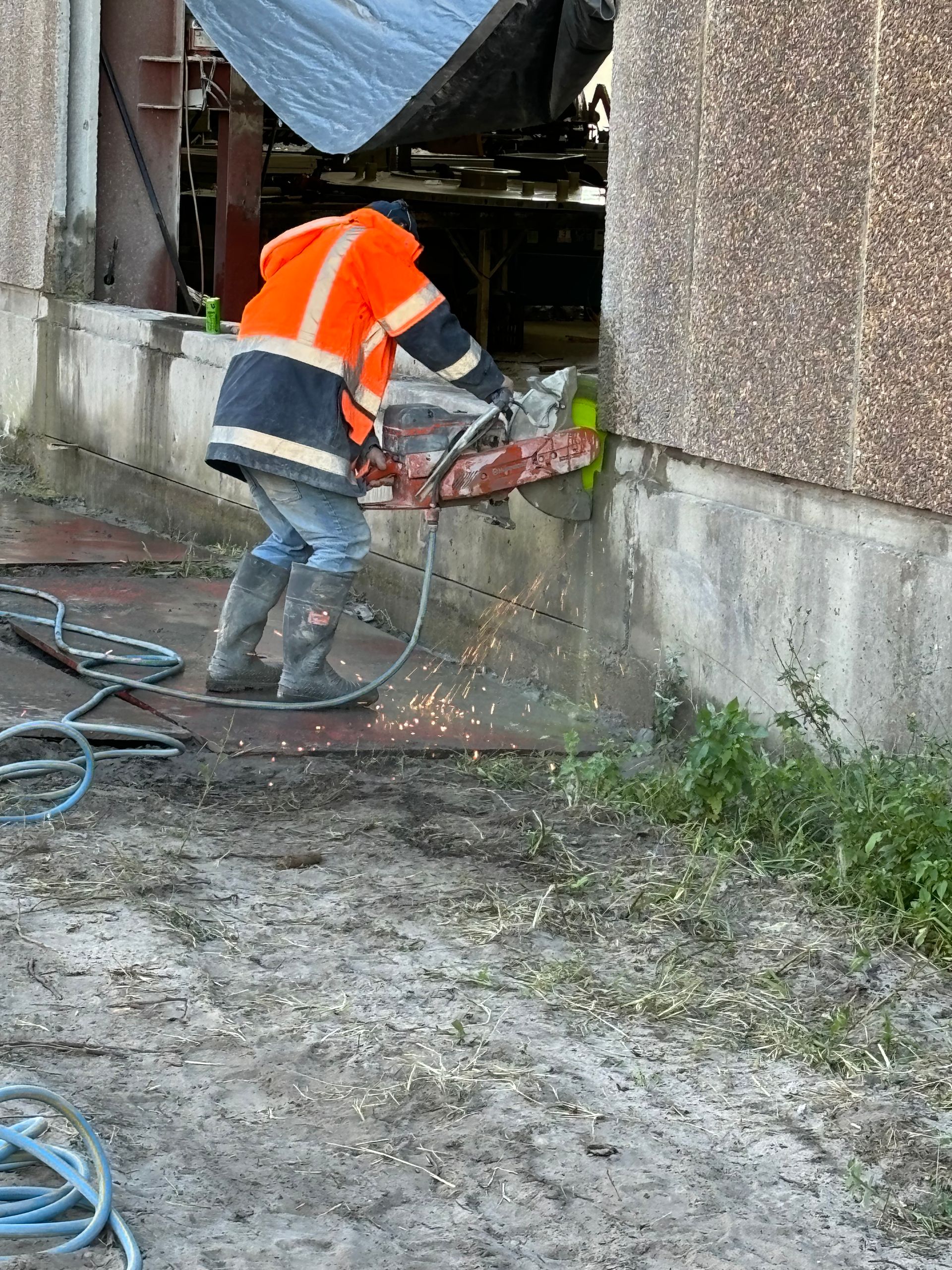A man is using a circular saw to cut concrete. — Newcastle Cut & Drill In Boolaroo, NSW