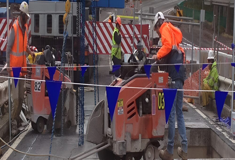 A Group Of Construction Workers Are Working On A Road — Newcastle Cut & Drill In Boolaroo, NSW