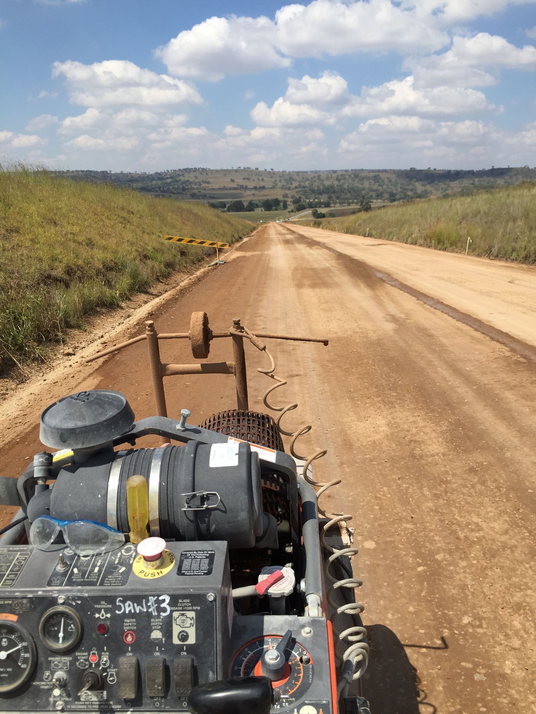 A machine is cutting concrete on a dirt road — Newcastle Cut & Drill In Boolaroo, NSW