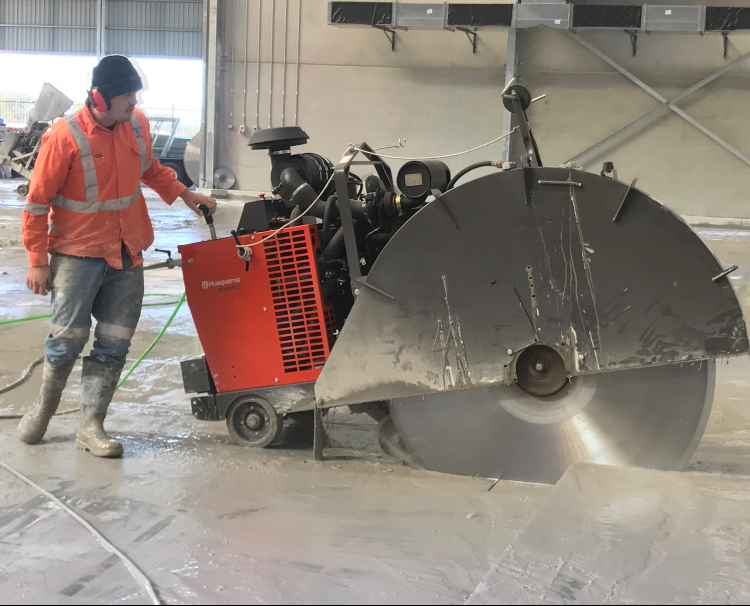 A person is using a concrete saw to cut concrete — Newcastle Cut & Drill In Boolaroo, NSW