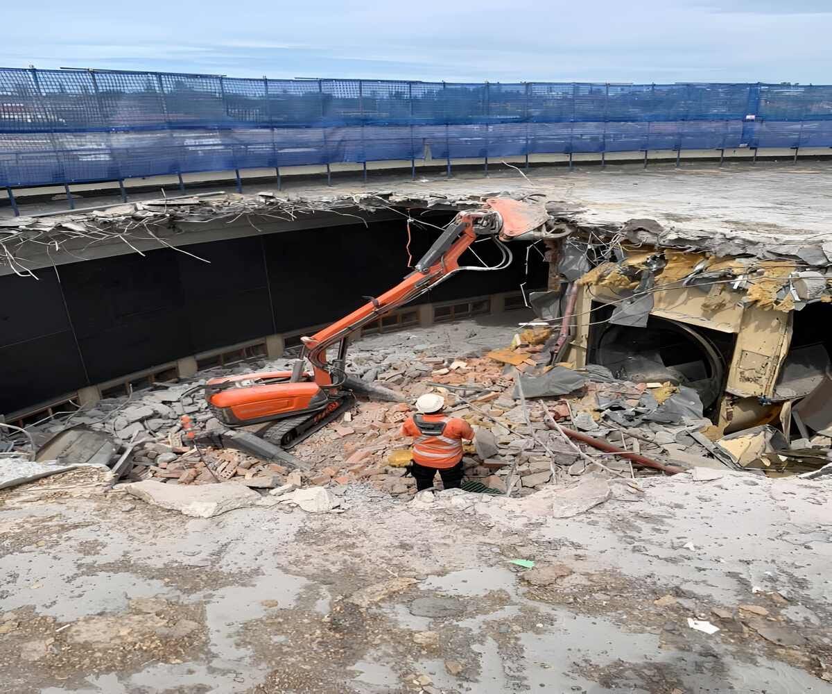 A Construction Worker Is Standing In The Middle Of A Demolition Site — Newcastle Cut & Drill In Boolaroo, NSW