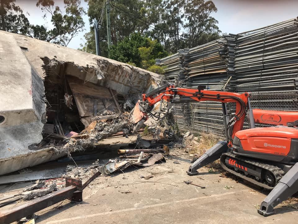 A Large Concrete Structure Is Being Demolished By A Robotic Excavator — Newcastle Cut & Drill In Boolaroo, NSW