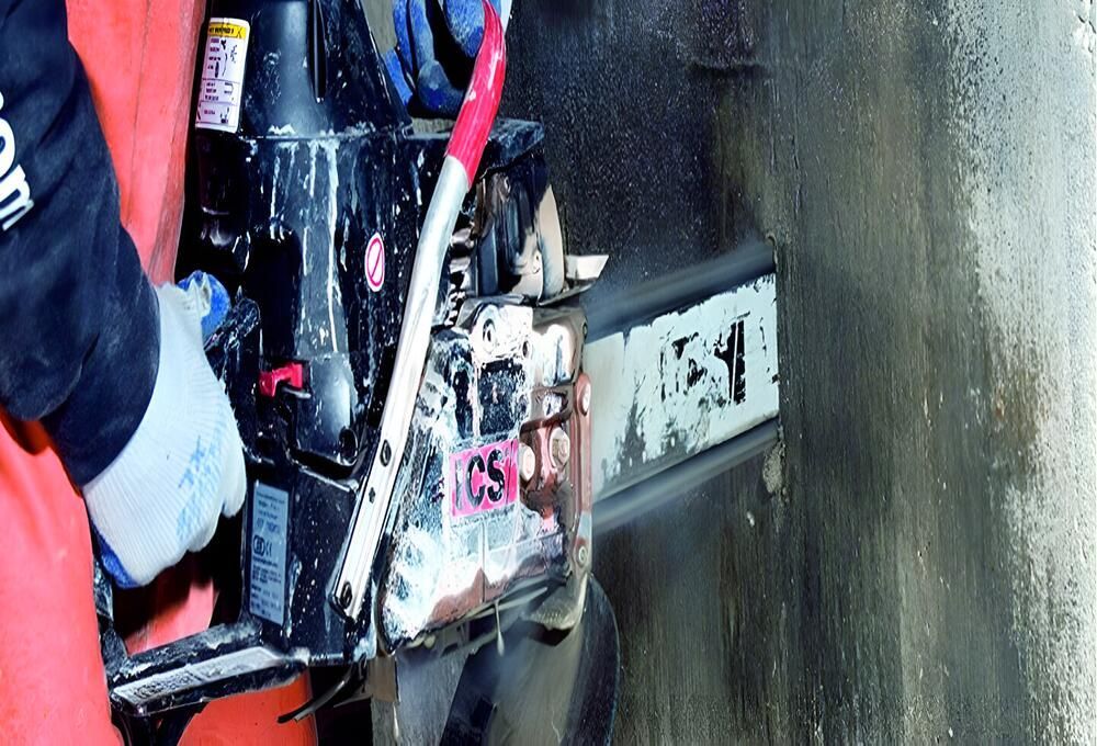 A Person Is Using A Chainsaw To Cut A Hole In A Wall — Newcastle Cut & Drill In Boolaroo, NSW