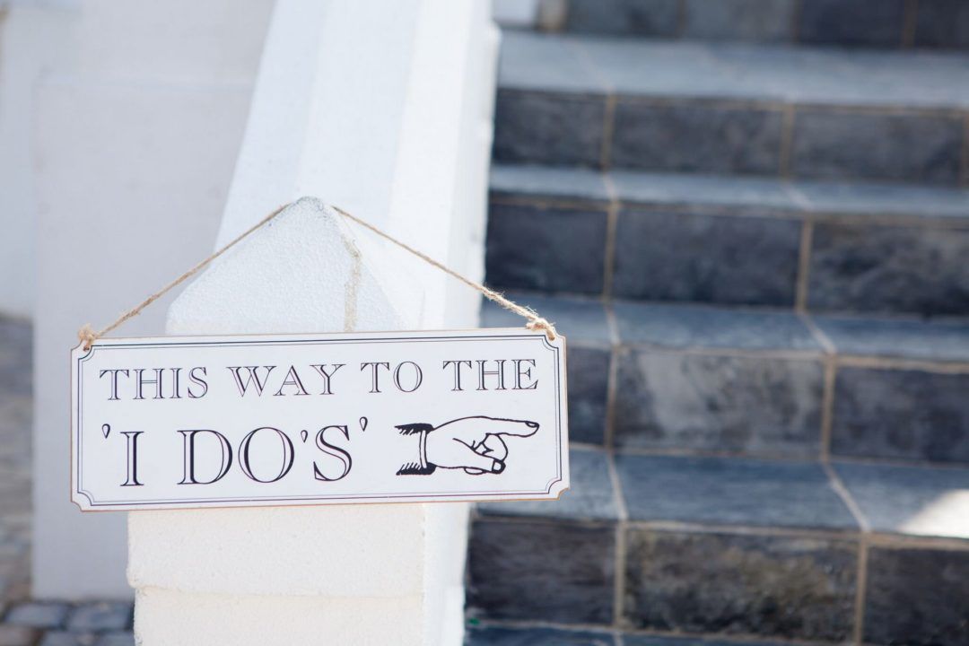 A sign hanging on a railing that says this way to the i do 's is