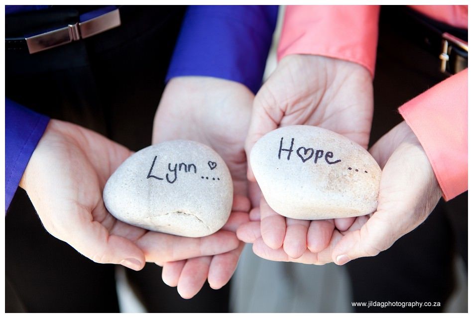 A person is holding two rocks in their hands that say lynn and hope