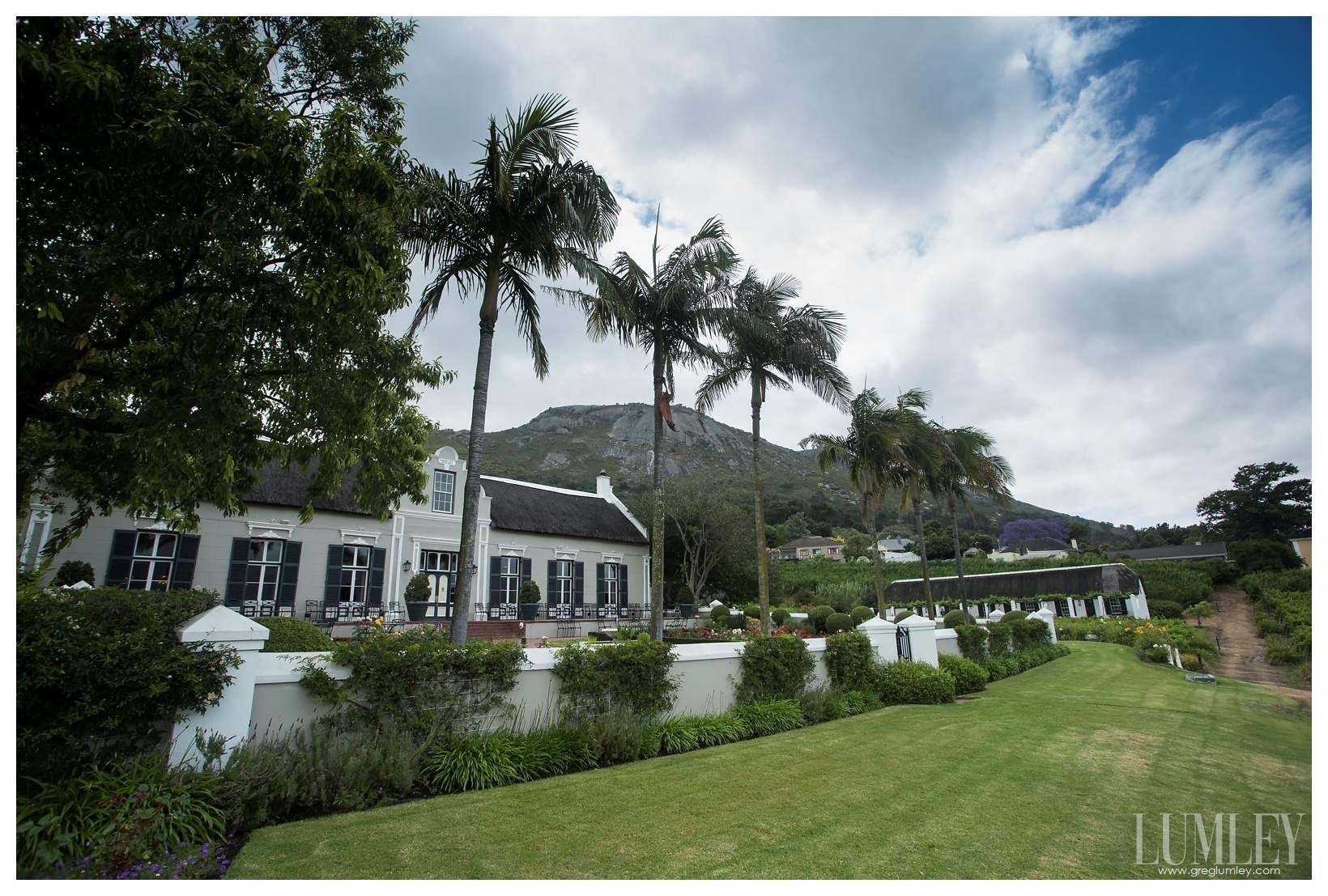 A large white house with palm trees in front of it