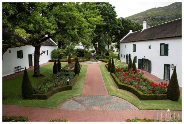 A row of white buildings with a brick walkway between them