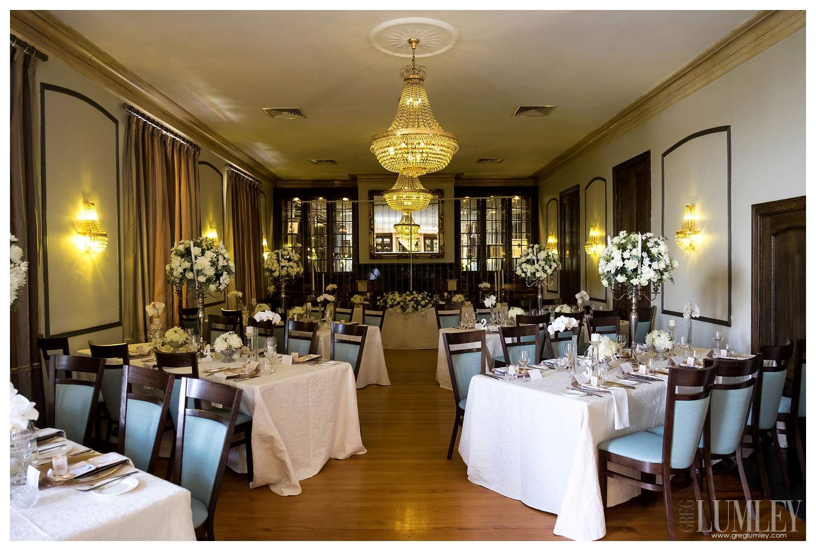 A large room with tables and chairs set up for a wedding reception.