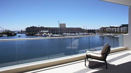 A chair is sitting on a balcony overlooking a body of water.