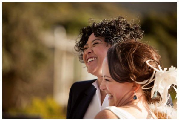 A bride and groom are smiling and hugging each other