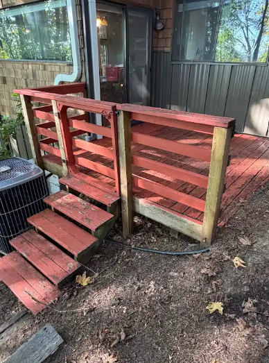 Wooden deck with tools and supplies laid out beside a person’s legs and boots during construction work